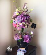 نمای پشت گلدان ساخته شده از گل های با رنگ های صورتی، سفید و بنفش